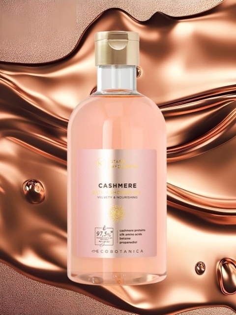 Żel do kąpieli i pod prysznic Cashmere 400 ml – Stara Mydlarnia, w tle płyn w miedzianym odcieniu